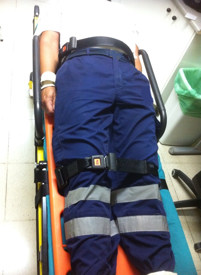 Una vez se coloque sobre la camilla, pasamos las cintas de la camilla de modo que sujeten el tablero espinal y no haya riesgo para el paciente en caso de un frenazo brusco.